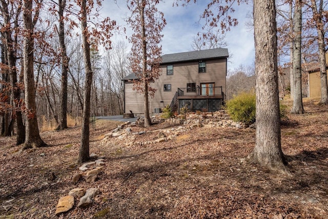 rear view of house with a wooden deck and stairs