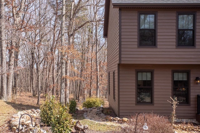 view of side of property with roof with shingles