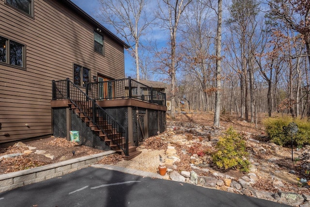 view of property exterior with stairway and a deck