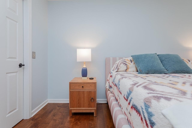 bedroom featuring baseboards and dark wood-style flooring