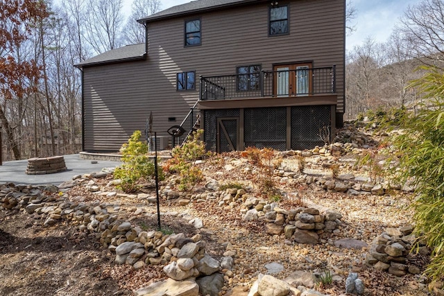 rear view of house with stairs, a deck, and an outdoor fire pit