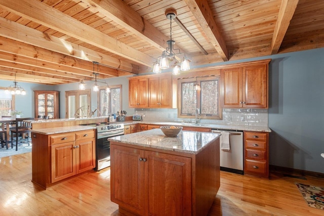 kitchen featuring tasteful backsplash, a kitchen island, appliances with stainless steel finishes, a peninsula, and a chandelier