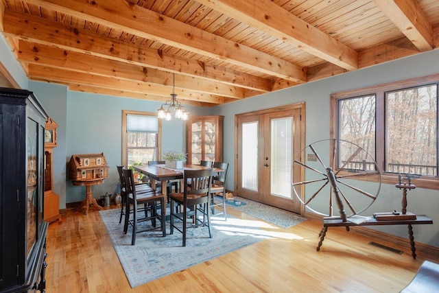 dining area featuring wood ceiling, french doors, light wood-style floors, beamed ceiling, and a notable chandelier