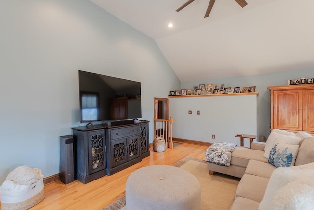 living area with vaulted ceiling, light wood-style flooring, a ceiling fan, and baseboards