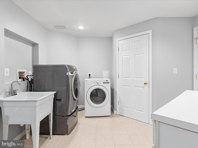 washroom with light tile patterned flooring, laundry area, and independent washer and dryer