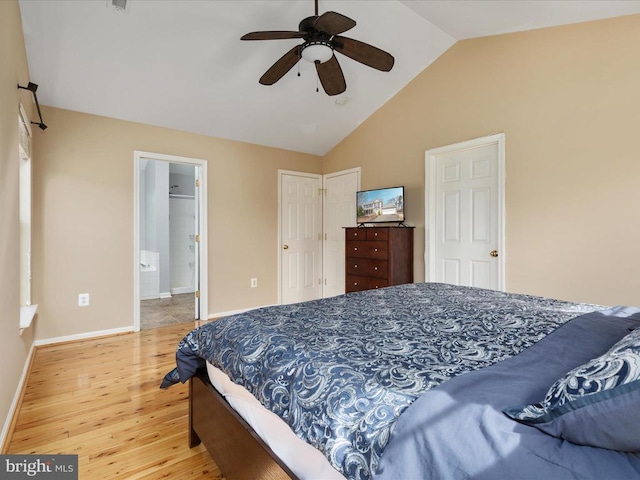 bedroom with a ceiling fan, baseboards, light wood finished floors, lofted ceiling, and connected bathroom