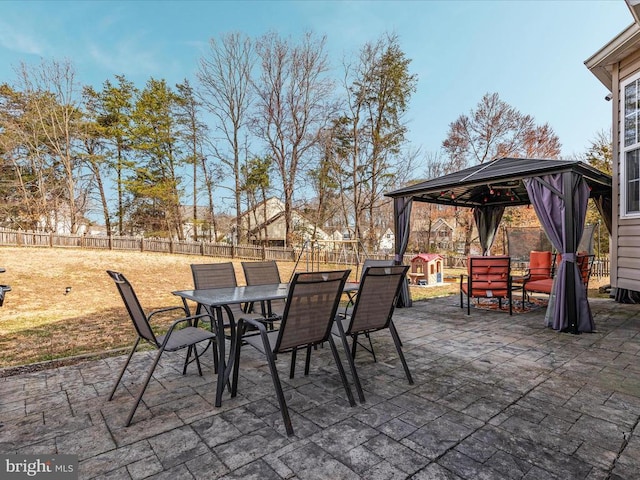 view of patio featuring a gazebo, outdoor dining area, and a fenced backyard