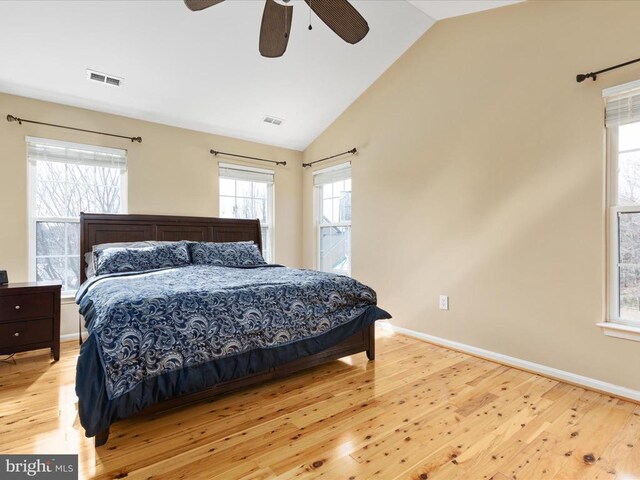 bedroom featuring light wood finished floors, visible vents, baseboards, and lofted ceiling