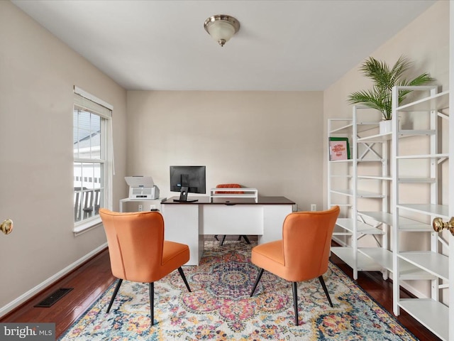 office area with wood finished floors, visible vents, and baseboards