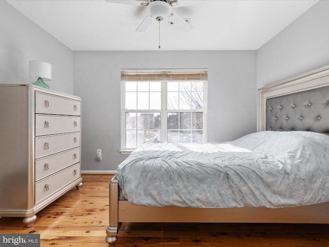 bedroom featuring baseboards, light wood-type flooring, and ceiling fan