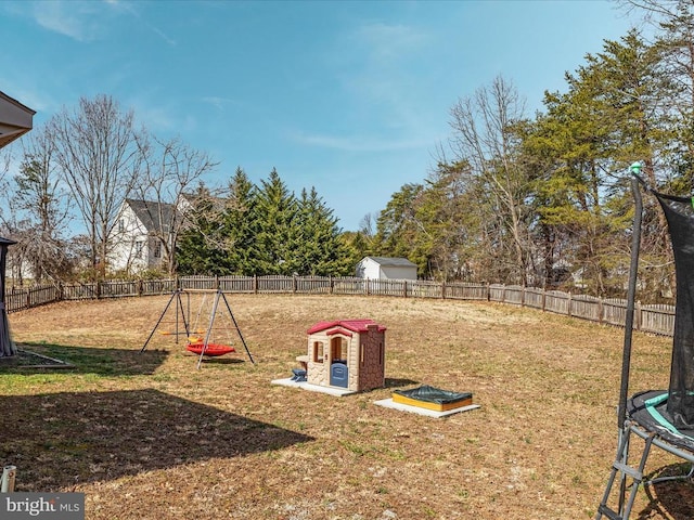 view of yard with a trampoline and a fenced backyard