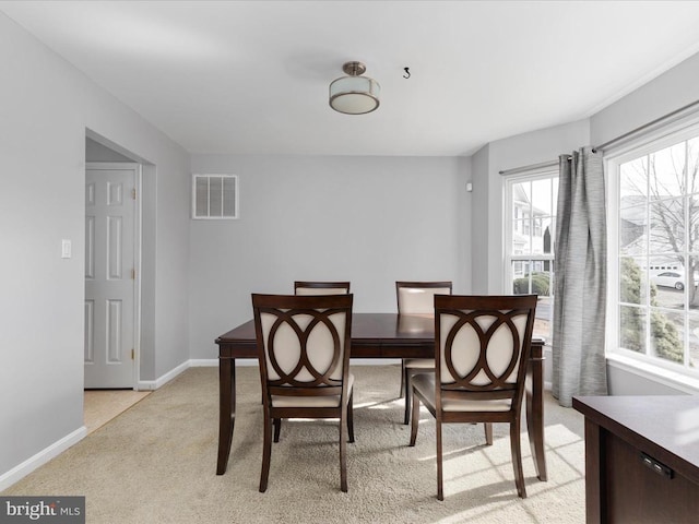 dining space with visible vents, light carpet, and baseboards