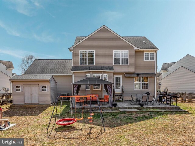 back of house featuring an outbuilding, a patio, fence, a shed, and a yard