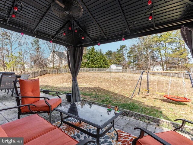 view of patio / terrace with a gazebo, a playground, and a fenced backyard