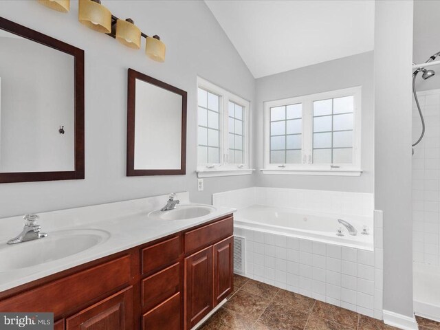 full bath with vaulted ceiling, a garden tub, visible vents, and a sink