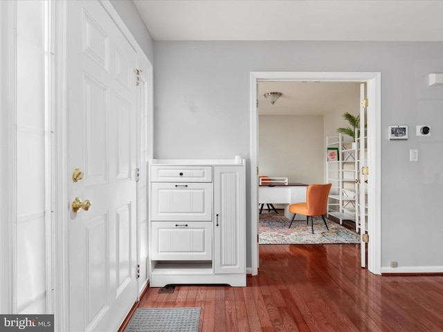 hallway with baseboards and wood finished floors