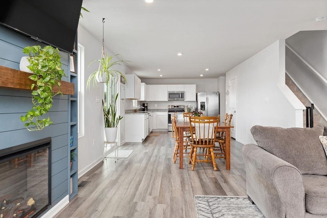 dining room with sink and light hardwood / wood-style flooring