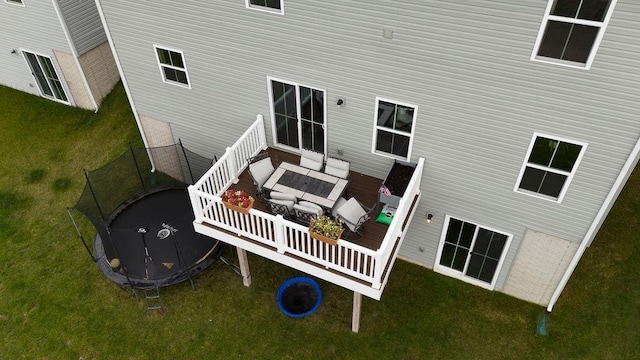 rear view of property with a yard and a trampoline