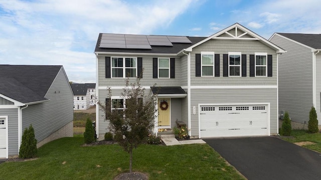 view of front of home with a garage, a front lawn, and solar panels