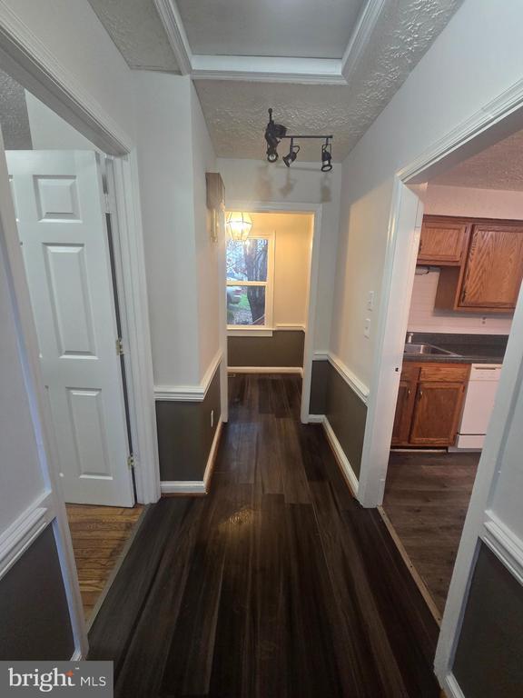 corridor featuring dark hardwood / wood-style flooring, sink, and a textured ceiling