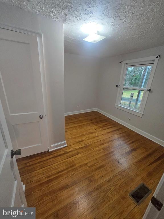 empty room featuring hardwood / wood-style floors and a textured ceiling