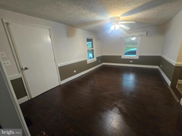 empty room featuring ceiling fan, dark hardwood / wood-style flooring, and a textured ceiling