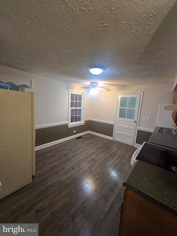 interior space featuring sink, a textured ceiling, and dark hardwood / wood-style flooring