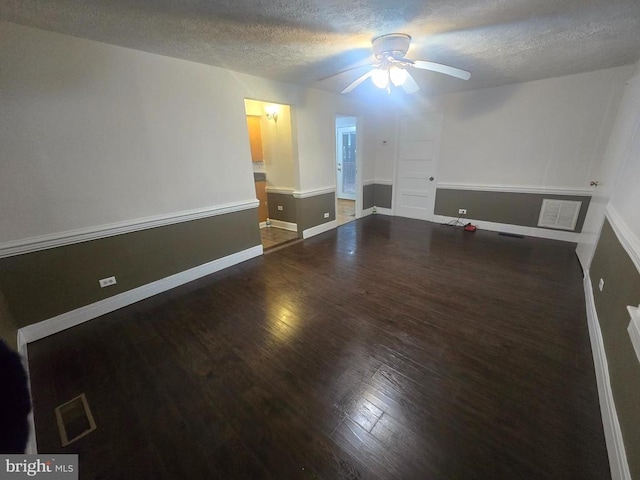 unfurnished room featuring ceiling fan, dark hardwood / wood-style floors, and a textured ceiling