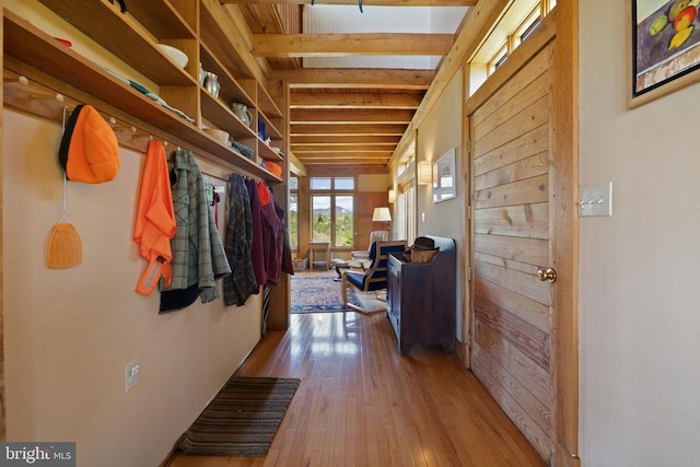 corridor with beam ceiling and hardwood / wood-style floors