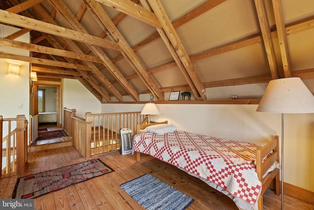 bedroom with wood-type flooring and lofted ceiling with beams