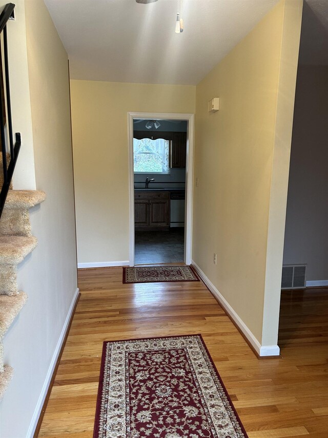 hall with sink and light hardwood / wood-style floors