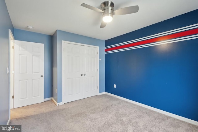 unfurnished bedroom with a closet, baseboards, a ceiling fan, and carpet