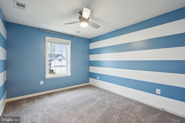 carpeted empty room featuring visible vents, ceiling fan, and baseboards