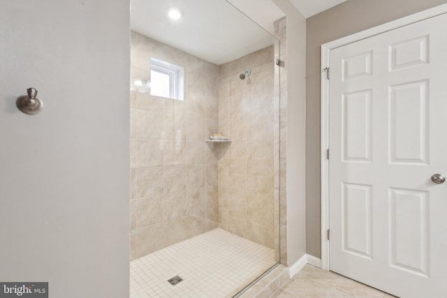 full bath featuring tile patterned floors, a shower stall, and baseboards