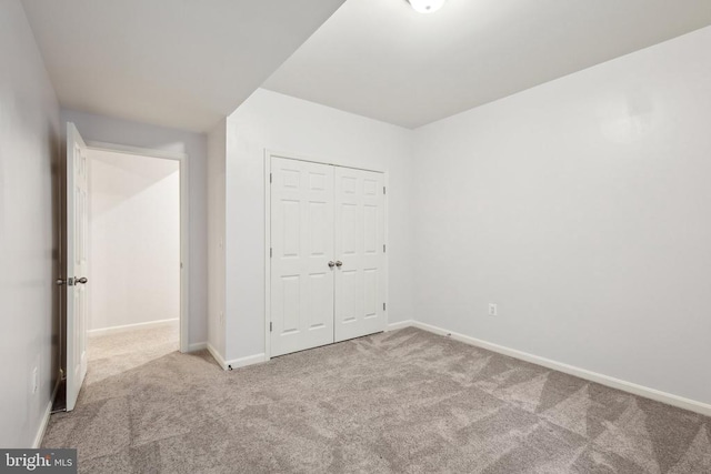 unfurnished bedroom featuring a closet, carpet flooring, and baseboards