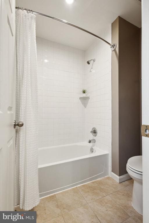 full bath featuring shower / bath combo, toilet, tile patterned floors, and baseboards