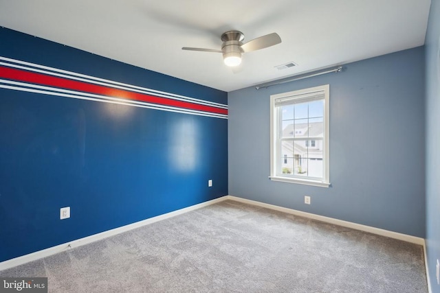 unfurnished room with carpet flooring, visible vents, baseboards, and ceiling fan