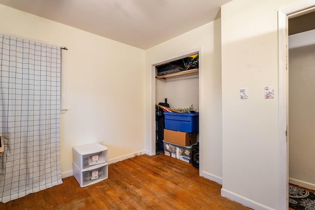 bedroom with a closet, baseboards, and wood finished floors