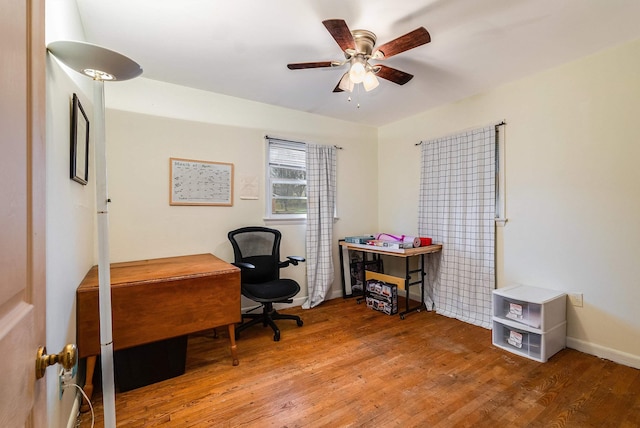 office area with wood finished floors, a ceiling fan, and baseboards