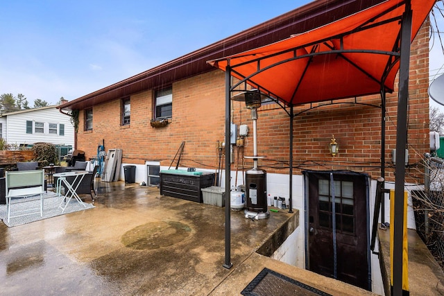 exterior space featuring a patio, brick siding, and a gazebo