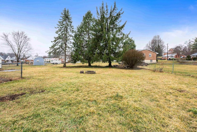 view of yard with an outdoor fire pit and fence