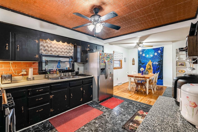 kitchen featuring appliances with stainless steel finishes, a sink, an ornate ceiling, and dark cabinetry