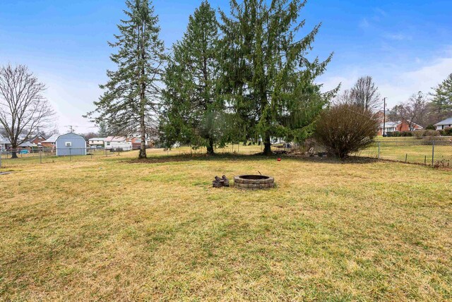 view of yard featuring an outdoor fire pit and fence