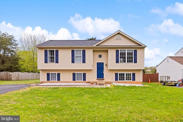 bi-level home with fence and a front lawn