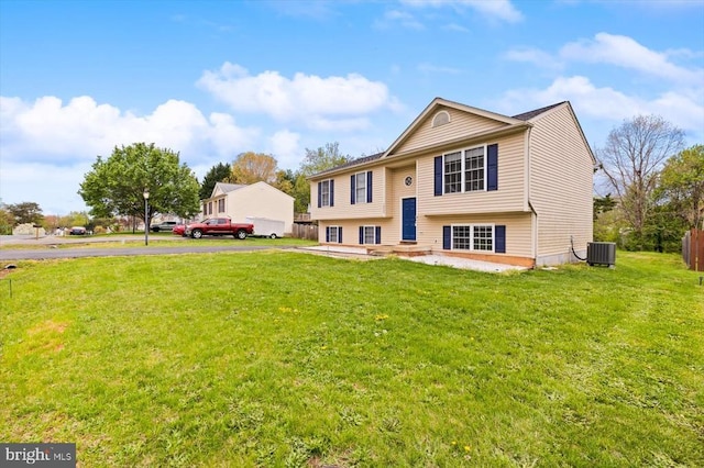 bi-level home with central AC and a front yard