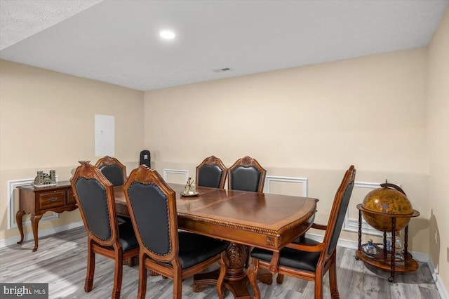 dining room featuring visible vents, baseboards, and wood finished floors