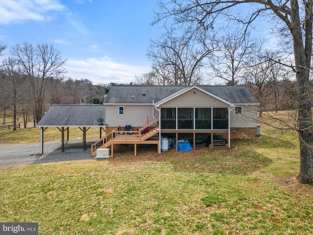 rear view of property with a deck, a yard, and a sunroom