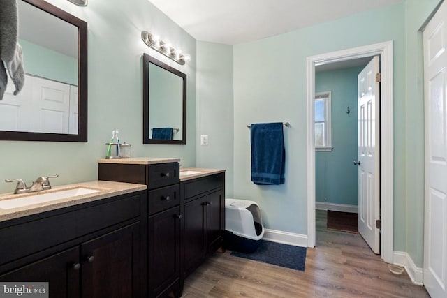 bathroom featuring vanity, baseboards, and wood finished floors