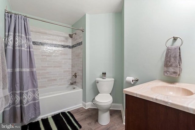 full bathroom with shower / bath combo with shower curtain, toilet, wood finished floors, baseboards, and vanity