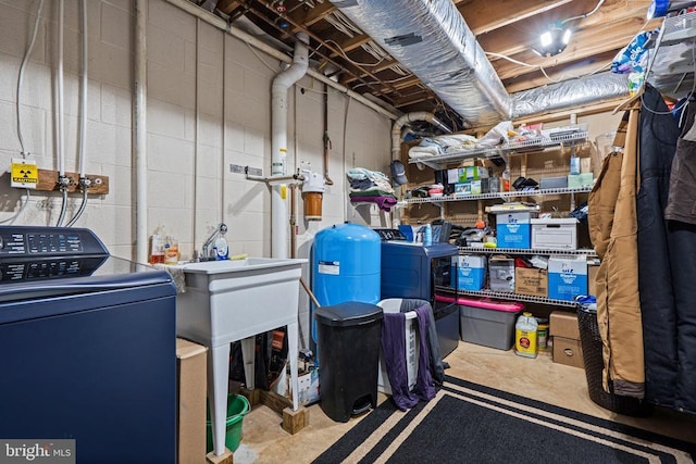 unfinished basement featuring washer / clothes dryer and concrete block wall